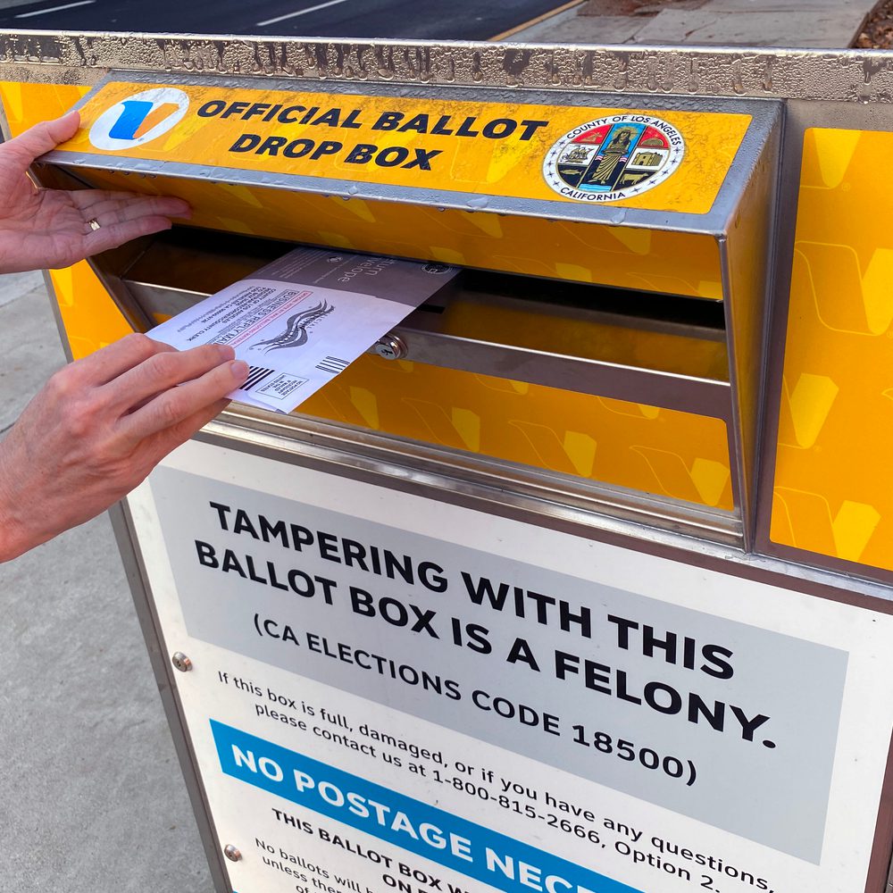 A voter puts a ballot into an official ballot drop box in Los Angeles County, California
