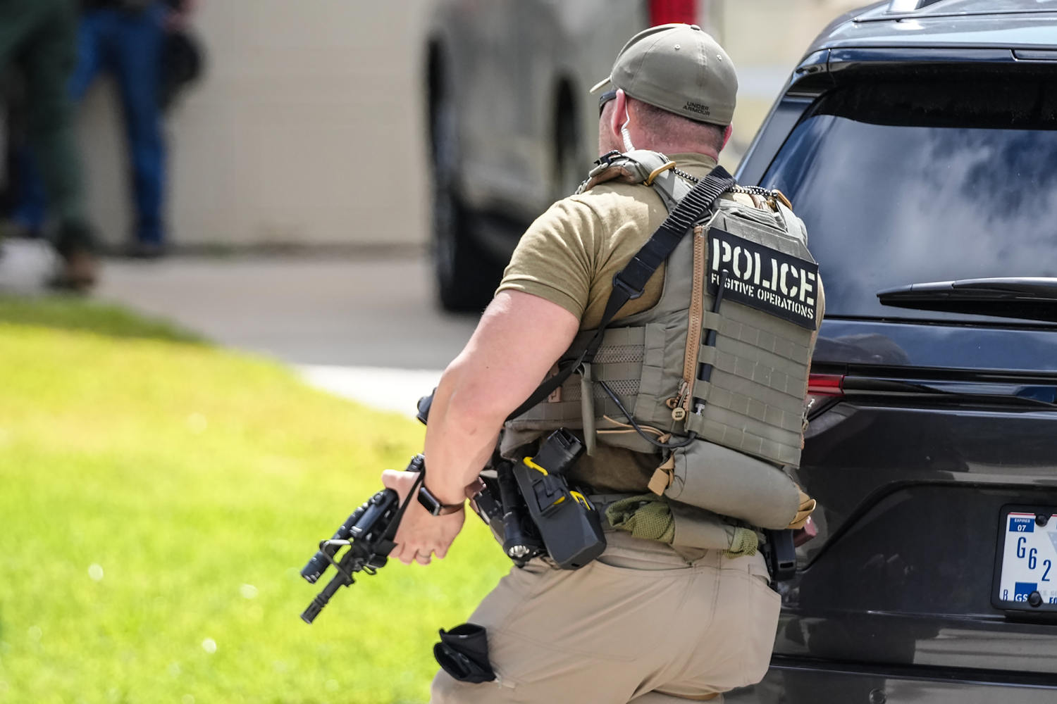 ICE officer beside an enforcement SUV