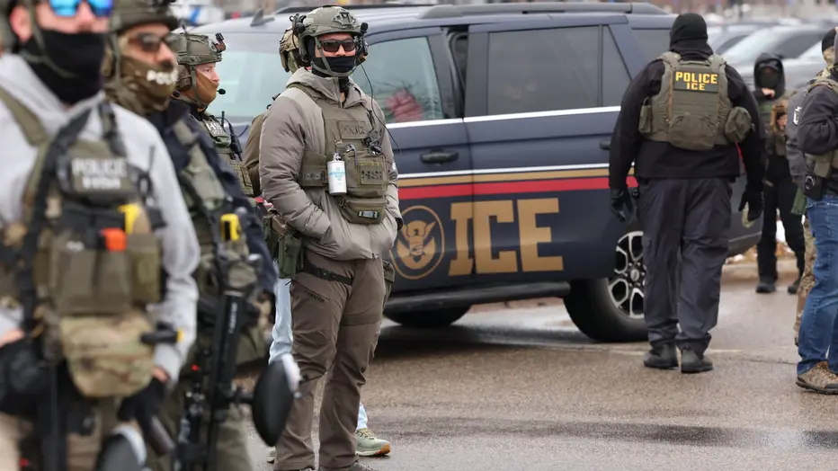 ICE agents with an immigration enforcement vehicle