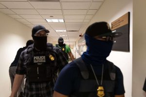 ICE officers walking down a hallway