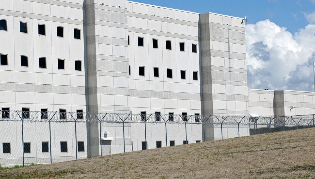 Correctional facility building with razor-wire fence